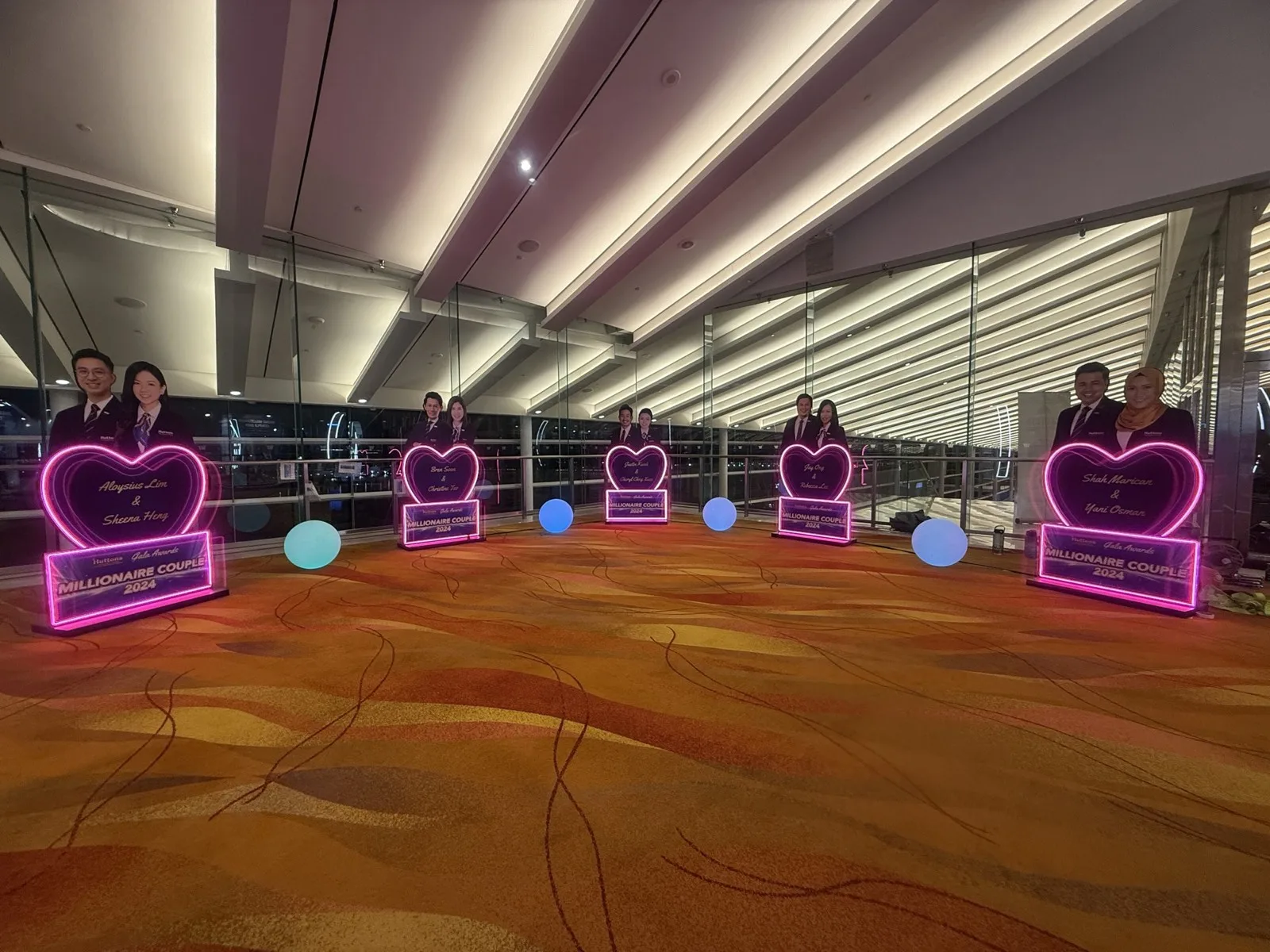 Award recipient displays illuminated in pink at the ballroom foyer