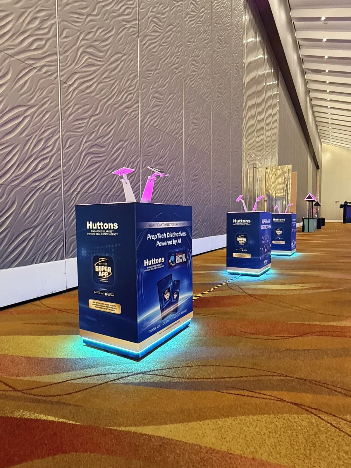 Illuminated Huttons interactive displays along the venue wall