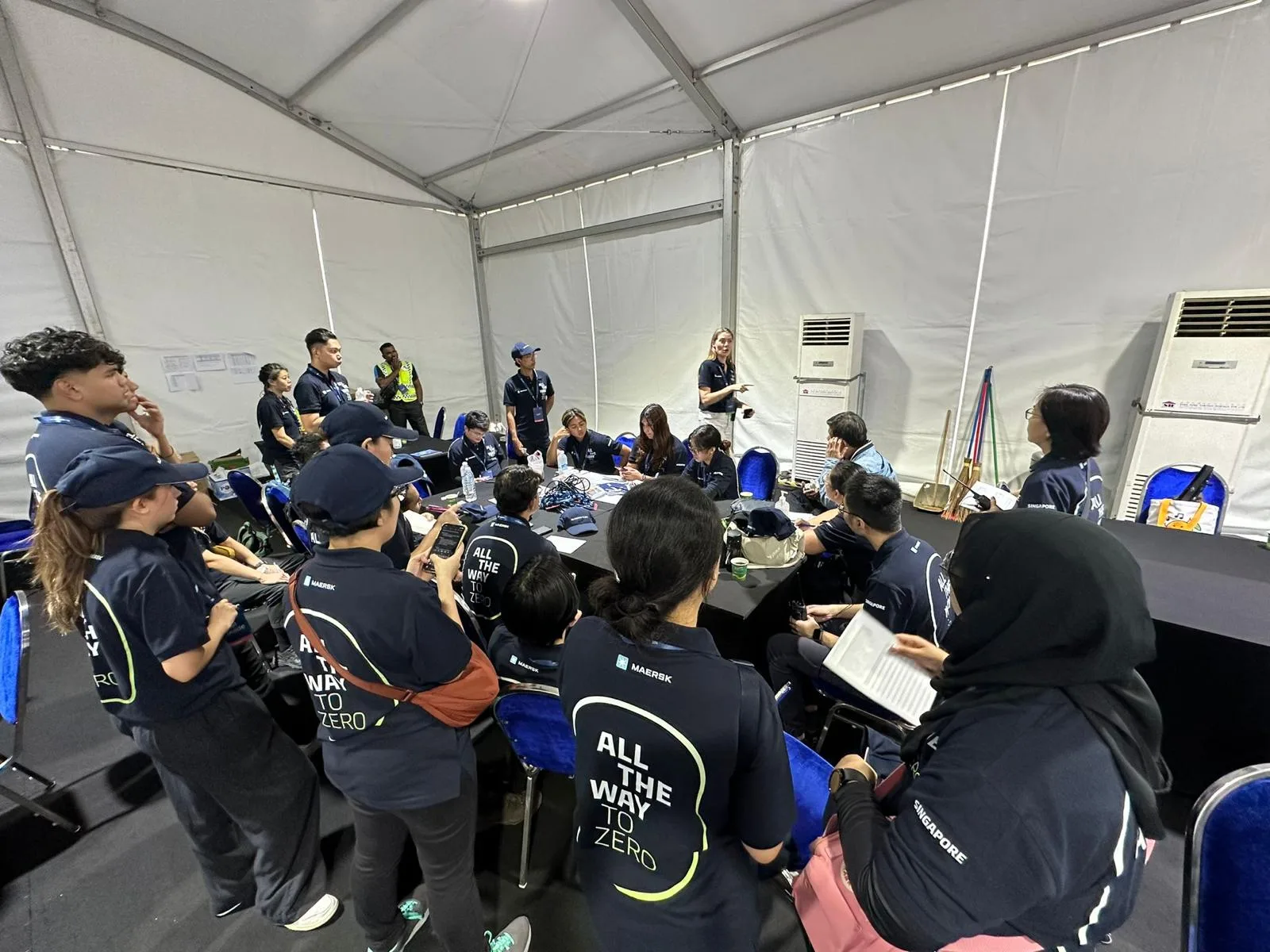 Event staff attending an on-site Maersk briefing