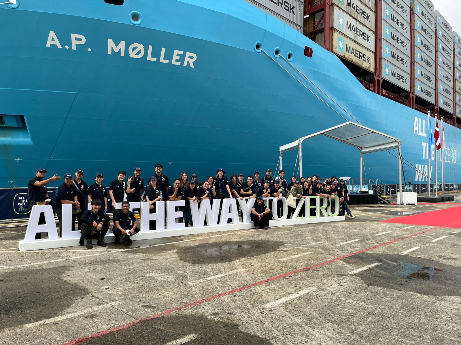 Maersk event team gathered beside a container vessel